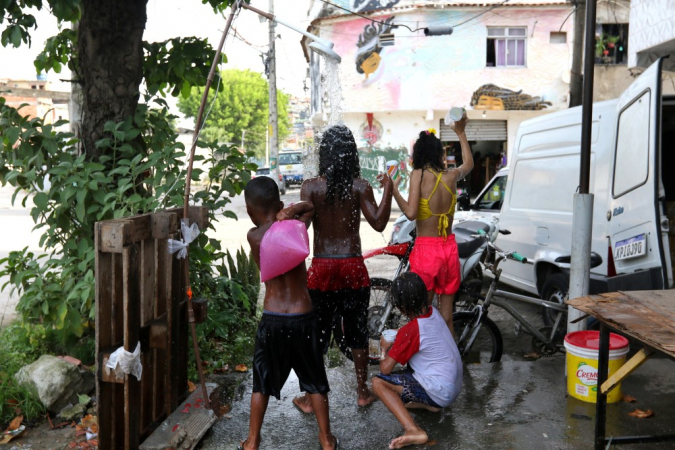 Moradores do Complexo da Maré se refrescam com chuveiros e piscinas improvisadas nas ruas da comunidade. A sensação térmica na cidade do Rio de Janeiro voltou a superar os 50 graus