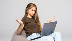 Mulher deprimida e frustrada que trabalha com o laptop do computador