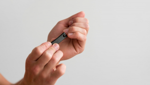 Vista lateral de um homem cuidando de suas unhas