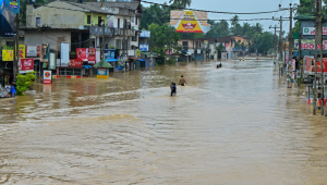 Pessoas atravessam uma rua alagada após fortes chuvas em Kaduwela, nos arredores de Colombo, no Sri Lanka