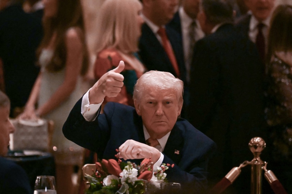 O presidente dos Estados Unidos, Donald Trump, faz sinal de positivo ao participar de um jantar de Natal em seu resort Mar-a-Lago, em Palm Beach, na Flórida