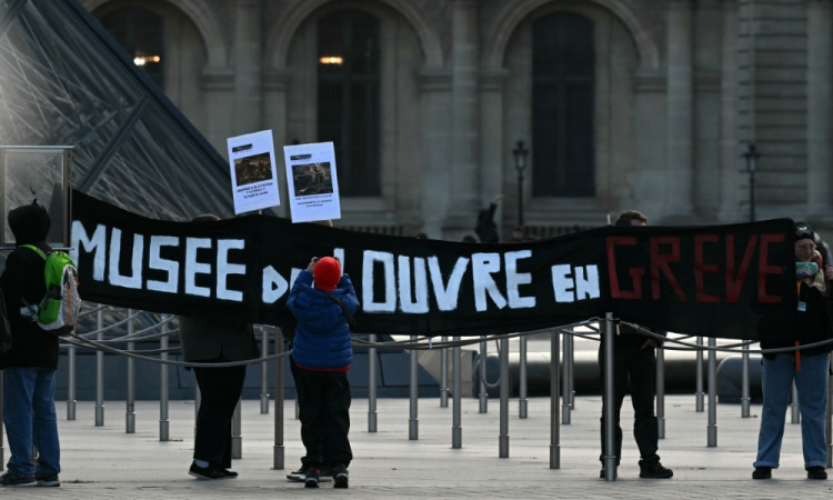 Funcionários do museu seguram uma faixa com os dizeres 'Museu do Louvre em greve' na entrada do Louvre