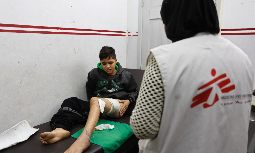 Um menino palestino ferido recebe atendimento de um membro da equipe dos Médicos Sem Fronteiras (MSF) em uma clínica no bairro de al-Rimal, na Cidade de Gaza, na véspera de Ano Novo, 31 de dezembro de 2025. Israel afirmou que 37 organizações de ajuda humanitária serão proibidas de operar em Gaza a partir de 1º de janeiro de 2026, a menos que cumpram as diretrizes que exigem informações detalhadas sobre a equipe palestina, o que gerou críticas das Nações Unidas e da União Europeia.