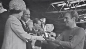 Bobby Moore, capitão da Inglaterra na Copa do Mundo de 1966, recebe a taça Jules Rimet das mãos da rainha Elizabeth II