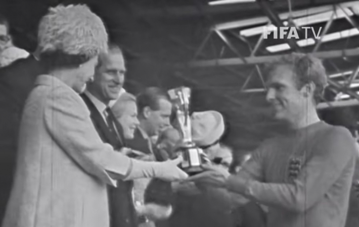 Bobby Moore, capitão da Inglaterra na Copa do Mundo de 1966, recebe a taça Jules Rimet das mãos da rainha Elizabeth II