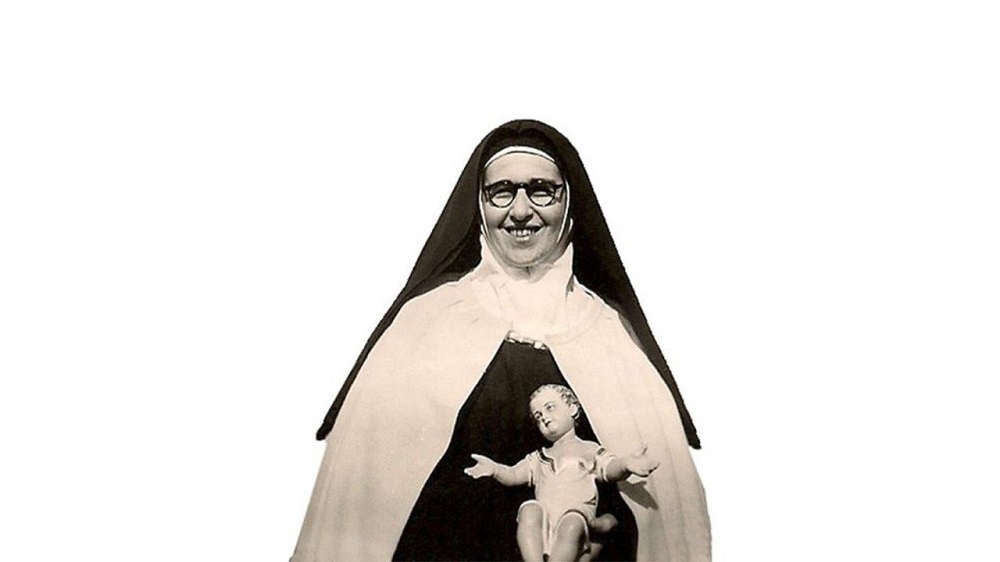 Maria Giselda Villela segurando a imagem de um Bebê respresentado Jesus Cristo