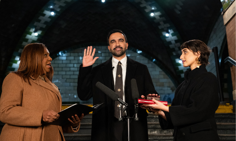 O prefeito eleito de Nova York, Zohran Mamdani (C), toma posse enquanto a procuradora-geral de Nova York, Letitia James (E), e sua esposa, Rama Duwaji, observam, em Nova York, em 1º de janeiro de 2026. O prefeito eleito de Nova York, Zohran Mamdani, está prestes a se tornar o primeiro prefeito muçulmano da cidade americana, e o otimismo juvenil de sua plataforma socialista democrática será posto à prova quando ele assumir o cargo em 1º de janeiro de 2026, com grandes expectativas.