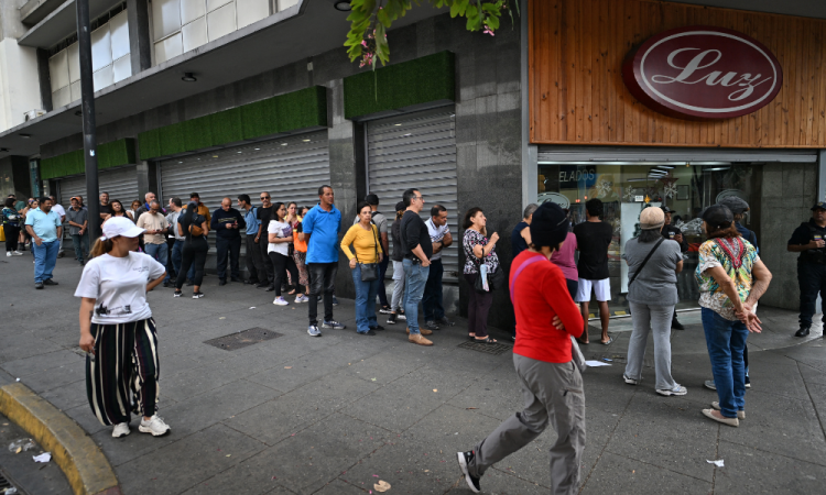 Pessoas fazem fila do lado de fora de um supermercado em Caracas em 3 de janeiro de 2026, após as forças americanas capturarem o líder venezuelano Nicolás Maduro. O presidente Donald Trump disse no sábado que as forças americanas capturaram o líder da Venezuela, Nicolás Maduro, após bombardear a capital Caracas e outras cidades, em um clímax dramático para um impasse de meses entre Trump e seu arqui-inimigo venezuelano.