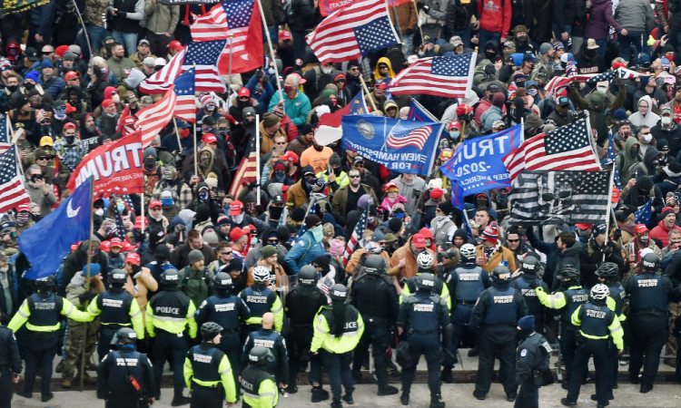 Uma imagem de arquivo datada de 6 de janeiro de 2021 mostra apoiadores de Trump entrando em confronto com a polícia e as forças de segurança ao invadirem o Capitólio dos EUA em Washington, DC, depois que manifestantes romperam a segurança e entraram no prédio enquanto o Congresso contabilizava os votos para a Certificação do Voto Eleitoral da eleição presidencial de 2020. 6 de janeiro de 2026 marca cinco anos desde que uma multidão invadiu o Capitólio dos EUA em Washington, DC, com os manifestantes perdoados por Donald Trump refazendo seus passos enquanto os democratas retomam as audiências para responsabilizar o presidente.