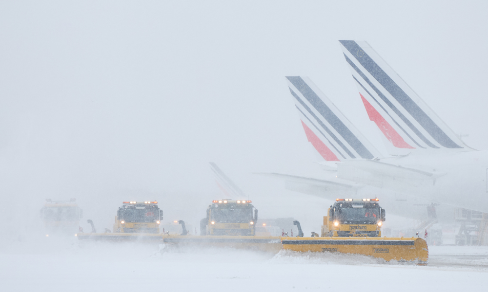 Aviões da Air France são vistos na pista enquanto limpa-neves limpam as pistas após fortes nevascas, que causaram cancelamentos de voos no Aeroporto de Orly, ao sul de Paris, em 7 de janeiro de 2026. Cerca de 100 voos foram cancelados no aeroporto Charles de Gaulle, em Paris, devido à queda de neve e ao frio intenso, e outros 40 foram cancelados no aeroporto de Orly, disse o ministro dos transportes da França. Conteúdo relacionado