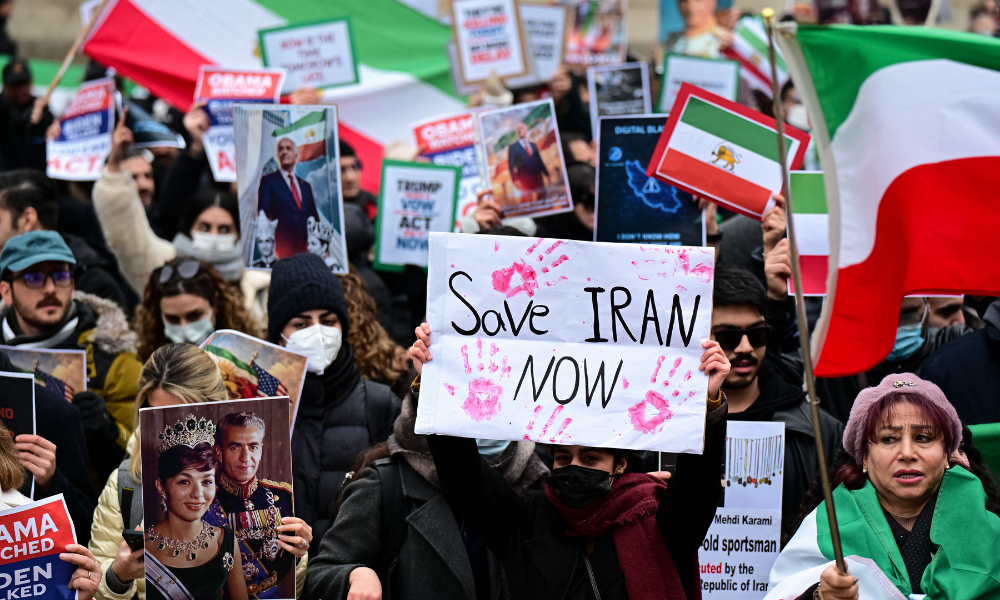 Manifestantes anti-regime iraniano entoam slogans e exibem cartazes durante um protesto em frente ao Consulado dos EUA em Milão, em 13 de janeiro de 2026. (Foto de Piero Cruciatti / AFP)