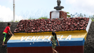 Crianças brincam em marco da fronteira entre Brasil e Venezuela.