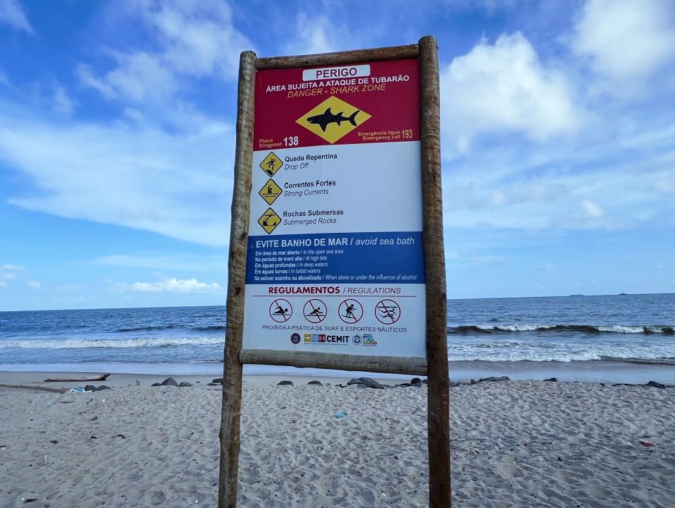 Placa de aviso para perigo de incidente envolvendo tubarão fixada na faixa de areia da Praia del Chifre, em Olinda, em Pernambuco