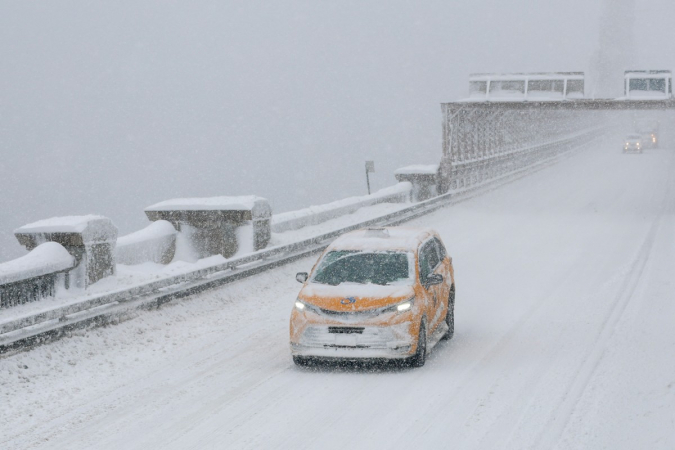 Um táxi amarelo atravessa a ponte do Brooklyn durante uma tempestade de inverno na cidade de Nova York em 23 de fevereiro de 2026.