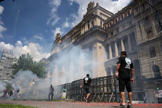 Servidores da Justiça do Trabalho soltam rojões durante um protesto contra a reforma trabalhista promovida pelo presidente da Argentina, Javier Milei, em frente ao tribunal em Buenos Aires, em 24 de fevereiro de 2026