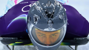 Atleta ucraniano Vladislav Heraskevych com capacete com imagens de atletas mortos durante o conflito com a Rússia