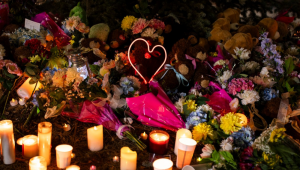 Flores e velas formam um memorial enquanto pessoas da comunidade prestam homenagem durante vigília às vítimas do massacre em uma escola no Canadá
