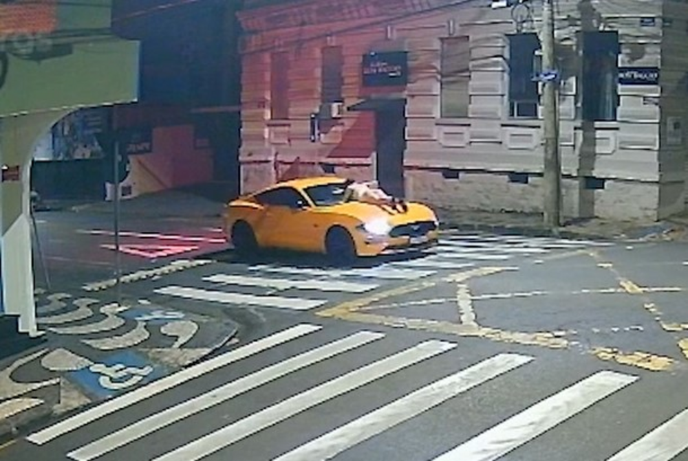 Mulher em cima do capô de Mustang