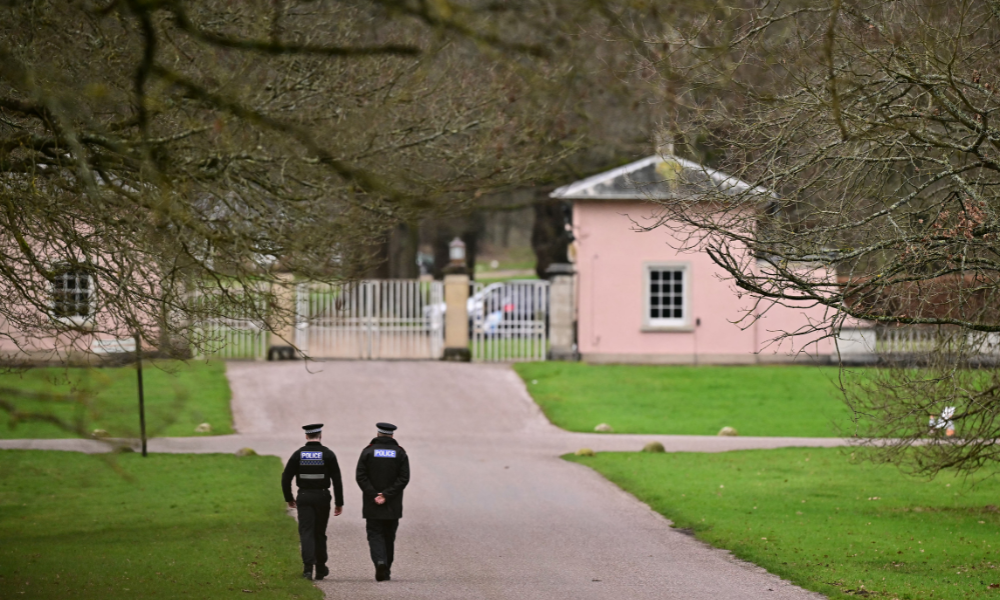 Agentes da polícia caminham em direção à entrada do Royal Lodge, uma propriedade de 30 quartos e antiga residência do ex-príncipe Andrew da Grã-Bretanha, onde a polícia disse que ainda está realizando uma busca, em Windsor, a oeste de Londres, em 20 de fevereiro de 2026, um dia depois de Andrew Mountbatten-Windsor ter sido preso na remota propriedade da família real em Sandringham, no leste da Inglaterra. A família real britânica entrou em crise em 19 de fevereiro, depois que o ex-príncipe Andrew foi preso pela polícia e mantido sob custódia por horas, em um golpe para a monarquia sem precedentes na história britânica moderna.