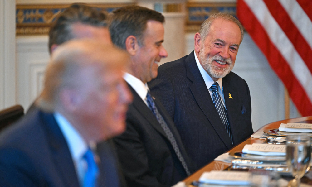 O embaixador dos EUA em Israel, Mike Huckabee (à direita), sorri enquanto o presidente dos EUA, Donald Trump (à esquerda), se reúne com o primeiro-ministro israelense, Benjamin Netanyahu, que não aparece na foto, no Salão Azul da Casa Branca, em Washington, DC, em 7 de julho de 2025. O primeiro-ministro Netanyahu se reunirá na segunda-feira com o presidente Trump, que expressou esperança de um "acordo esta semana" entre Israel e o Hamas que resulte na libertação de reféns da Faixa de Gaza. As negociações indiretas entre Israel e o Hamas começaram em 6 de julho em Doha, com o objetivo de intermediar um cessar-fogo e chegar a um acordo sobre a libertação de reféns em troca de prisioneiros palestinos.