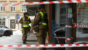 Agentes da lei ucranianos isolam a área no local de uma explosão que atingiu uma loja em Lviv em 22 de fevereiro de 2026, em meio à invasão russa da Ucrânia. Explosões atingiram uma rua comercial central por volta da meia-noite, matando uma policial e ferindo 25 pessoas depois que os agentes responderam a uma denúncia de arrombamento.