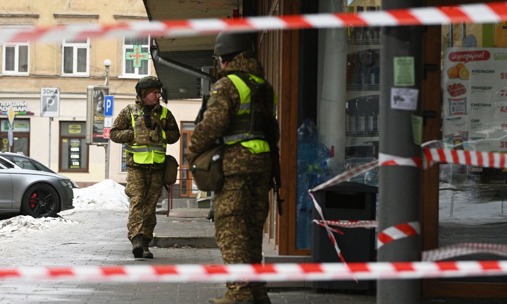 Agentes da lei ucranianos isolam a área no local de uma explosão que atingiu uma loja em Lviv em 22 de fevereiro de 2026, em meio à invasão russa da Ucrânia. Explosões atingiram uma rua comercial central por volta da meia-noite, matando uma policial e ferindo 25 pessoas depois que os agentes responderam a uma denúncia de arrombamento.