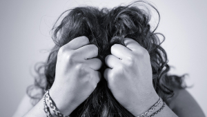 Imagem ilustrativa de uma pessoa cabisbaixa segurando o cabelo