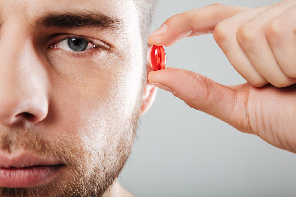 Retrato de um homem concentrado segurando a cápsula vermelha