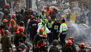 Agentes do serviço de emergência israelense removem um saco mortuário do local de um ataque de mísseis perto de Bet Shemesh, a cerca de 30 quilômetros a oeste de Jerusalém, em 1º de março de 2026.