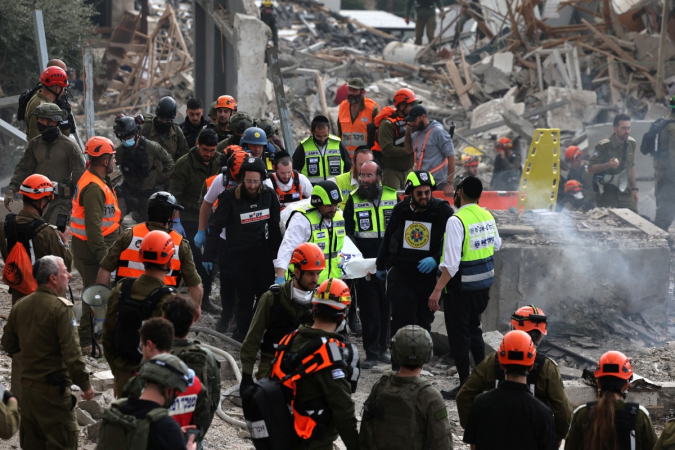 Agentes do serviço de emergência israelense removem um saco mortuário do local de um ataque de mísseis perto de Bet Shemesh, a cerca de 30 quilômetros a oeste de Jerusalém, em 1º de março de 2026.
