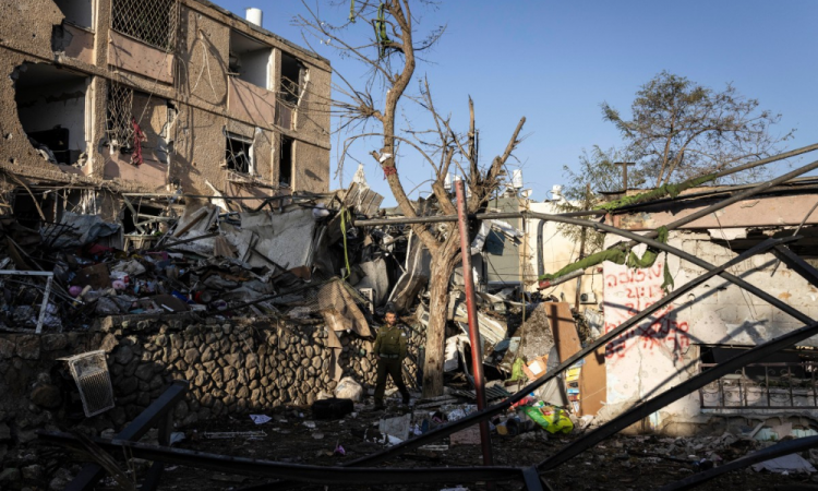 Agente de segurança israelense inspeciona o local de um ataque de míssil iraniano em Dimona, neste domingo (22)