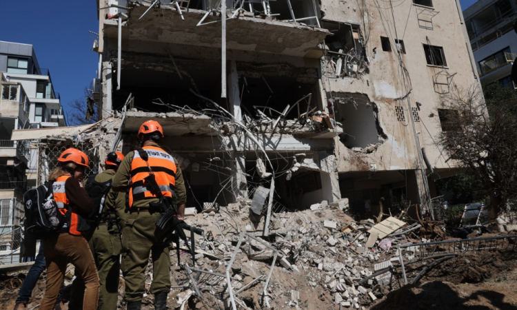 Equipes de emergência israelenses se reúnem no local de um ataque com míssil iraniano em Tel Aviv, nesta terça-feira (24)