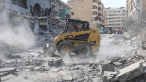 Trabalhador remove os destroços após um ataque aéreo israelense que teve como alvo os escritórios da Jamaa Islamiya, um grupo islâmico aliado ao Hamas e ao Hezbollah