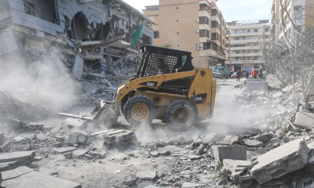 Trabalhador remove os destroços após um ataque aéreo israelense que teve como alvo os escritórios da Jamaa Islamiya, um grupo islâmico aliado ao Hamas e ao Hezbollah