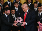 Lionel Messi entrega ao presidente dos EUA, Donald Trump, um trof&eacute;u em forma de bola durante um evento em homenagem ao Inter Miami CF, na Casa Branca