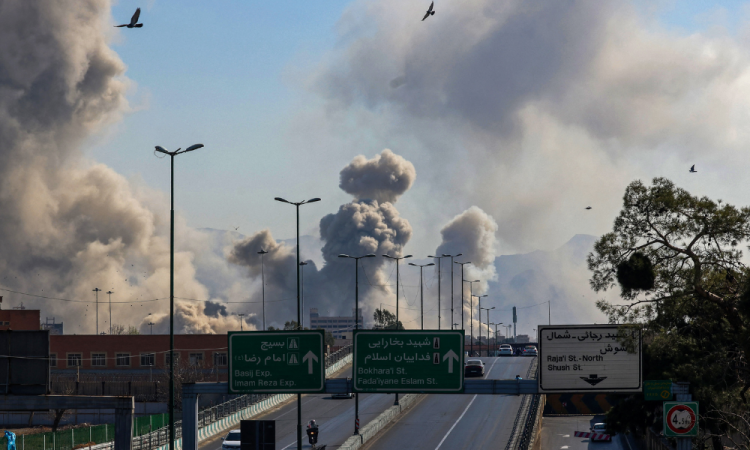 Motoristas trafegam por uma via expressa enquanto colunas de fumaça se elevam após um ataque em Teerã em 5 de março de 2026. Israel bombardeou Teerã com novos ataques e o Irã atacou grupos guerrilheiros curdos no Iraque em 5 de março, enquanto uma guerra crescente no Oriente Médio envolvia toda a região.