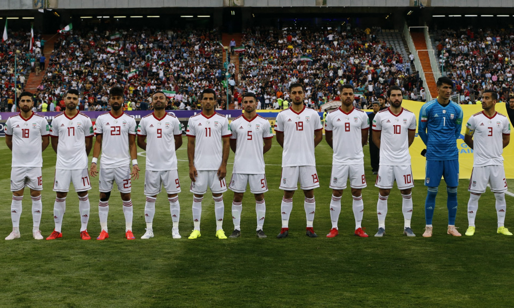 Jogadores do Irã ouvem o hino nacional durante o amistoso de futebol da FIFA entre Irã e Síria, no estádio Azadi, na capital iraniana, Teerã, em 6 de junho de 2019.