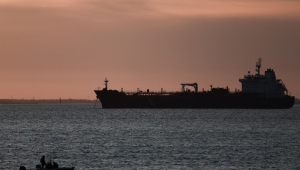 Esta fotografia mostra um pequeno barco em frente a um petroleiro ancorado no Grand Port Maritime de Marseille-Fos, ao pôr do sol, em Fos-sur-Mer, na costa mediterrânica do sul da França, em 13 de março de 2026. (Foto de Thibaud Moritz / AFP)