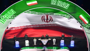 A bandeira do Irã é exibida em um telão durante o sorteio da Copa do Mundo FIFA de 2026, que será realizada nos Estados Unidos, Canadá e México, no Kennedy Center, em Washington, D.C., em 5 de dezembro de 2025. (Foto de Roberto Schmidt / AFP)