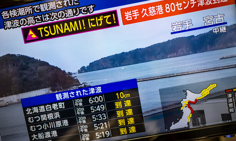Mensagem de alerta em uma tela de uma transmissão ao vivo da NHK com um aviso de tsunami após um terremoto atingir o norte do Japão nesta segunda-feira (20)