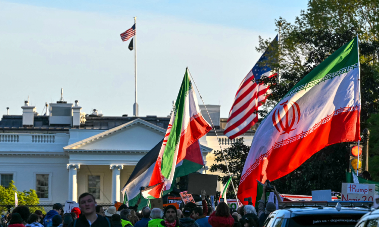 Manifestantes agitam bandeiras iranianas durante um protesto contra a ação militar dos EUA no Irã, perto da Casa Branca, em Washington