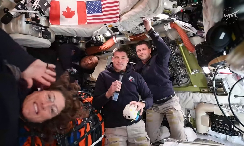 Esta captura de tela de uma transmissão ao vivo da NASA mostra (da esquerda para a direita) a astronauta da NASA e especialista da missão Artemis II, Christina Koch, o astronauta da NASA e piloto da Artemis II, Victor Glover, o astronauta da Agência Espacial Canadense e especialista da missão Artemis II, Jeremy Hansen, e o astronauta da NASA e comandante da Artemis II, Reid Wiseman, durante uma coletiva de imprensa enquanto viajam para a Lua na espaçonave Orion, em 3 de abril de 2026. Os quatro astronautas da Artemis ultrapassaram o ponto intermediário entre a Terra e a Lua a caminho de seu sobrevoo lunar planejado, disse a NASA na noite de sexta-feira. "Vocês estão agora mais perto da Lua do que de nós na Terra", disse o controle da missão aos astronautas por volta das 23h (04h GMT), de acordo com a transmissão ao vivo oficial da agência espacial.