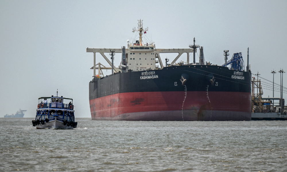 Um barco de passageiros passa navegando pelo petroleiro Kashimasan, de bandeira indiana, atracado perto de um terminal de descarregamento na Ilha Butcher, na costa de Mumbai, em 1º de abril de 2026. O Ministério do Petróleo da Índia afirmou em 1º de abril que os preços do combustível de aviação doméstico subiriam, já que a guerra no Oriente Médio elevou os custos de energia, mas que isso havia protegido as companhias aéreas de um aumento esperado de 100%.