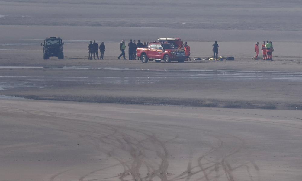FOTO DE DESTAQUE - Veículos de resgate e unidades médicas se reúnem na praia para atender as vítimas após uma tentativa de travessia ilegal do Canal da Mancha que terminou em tragédia, com vários migrantes encontrados em parada cardíaca, na cidade costeira de Equihen-Plage, no norte da França, em Pas-de-Calais, em 9 de abril de 2026. (Foto de Sameer AL-DOUMY / AFP)