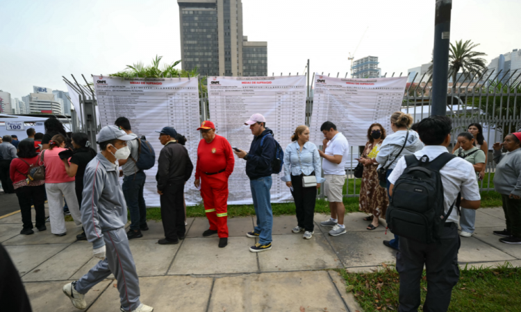 Pessoas aguardam em fila do lado de fora de uma seção eleitoral em Lima, em 12 de abril de 2026, durante as eleições gerais. Os peruanos elegerão um novo presidente entre um número recorde de 35 candidatos para liderar um país assolado pelo crime organizado e pela instabilidade política crônica.