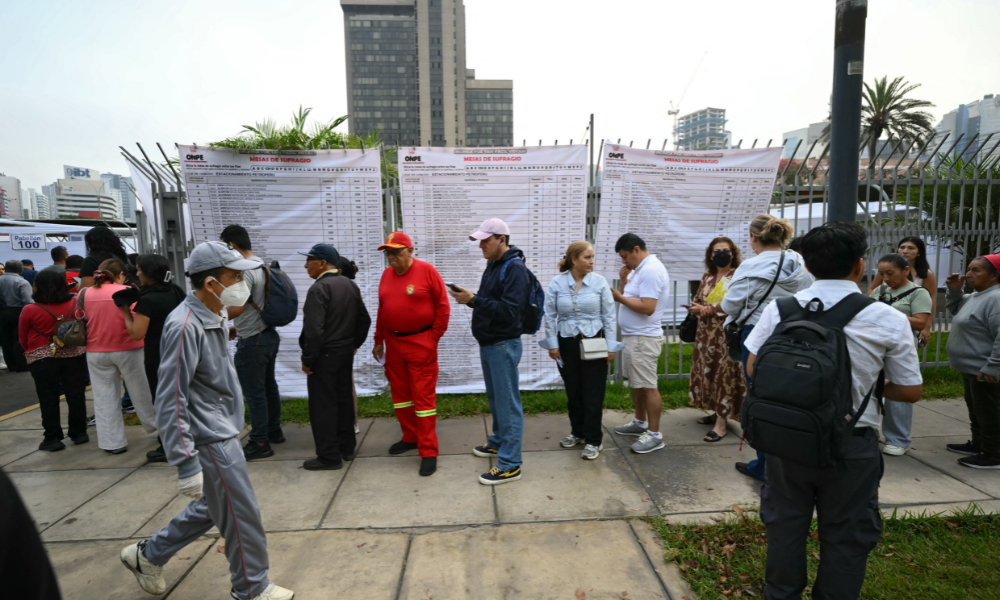 Pessoas aguardam em fila do lado de fora de uma seção eleitoral em Lima, em 12 de abril de 2026, durante as eleições gerais. Os peruanos elegerão um novo presidente entre um número recorde de 35 candidatos para liderar um país assolado pelo crime organizado e pela instabilidade política crônica.