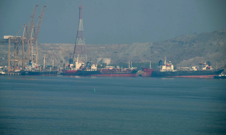 Navios-tanque são vistos no Terminal de Contêineres de Khor Fakkan, o único porto natural de águas profundas da região e um dos principais portos de contêineres do Emirado de Sharjah, ao longo do Estreito de Ormuz, uma hidrovia por onde passa um quinto da produção global de petróleo, em 23 de junho de 2025. Os militares dos EUA disseram que iniciariam um bloqueio a todos os portos iranianos em 13 de abril de 2026, após o colapso das negociações entre os lados em guerra no Paquistão, com o presidente dos EUA culpando a recusa do Irã em abandonar suas ambições nucleares.