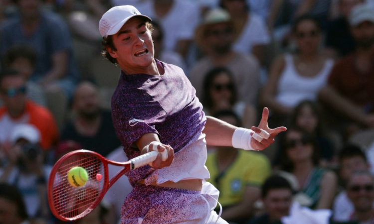 João Fonseca devolve uma bola de direita do francês Luka Pavlovic durante a partida de Roland Garros, neste domingo (24)