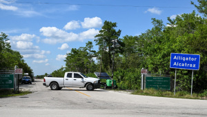 Veículo de um oficial da Flórida é visto na entrada do centro de detenção de imigrantes conhecido como 'Alligator Alcatraz'