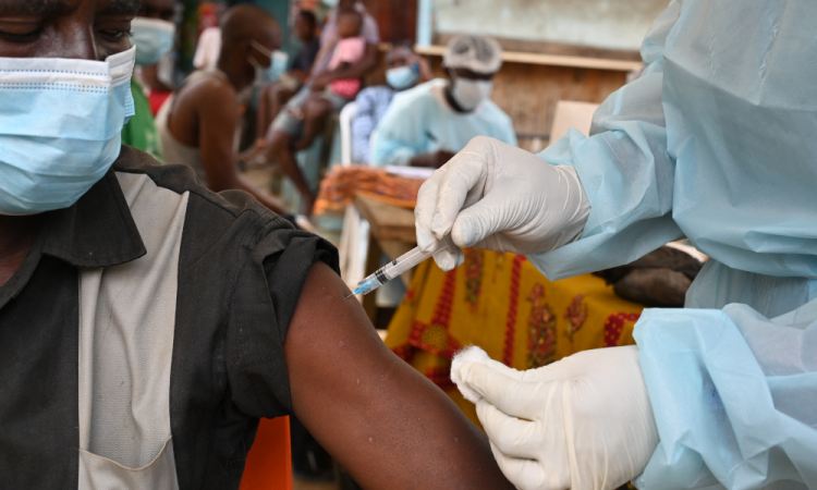 Um profissional de saúde vacina um homem em Abidjan, em 17 de agosto de 2021, durante uma campanha de vacinação contra o Ebola, após o país registrar seu primeiro caso conhecido da doença desde 1994. (Foto de Issouf Sanogo / AFP)